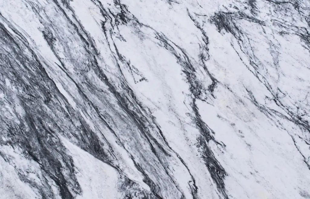 Close-up of a white marble slab with dramatic flowing gray and black veining for luxury countertops and feature walls in Knoxville, Tennessee.