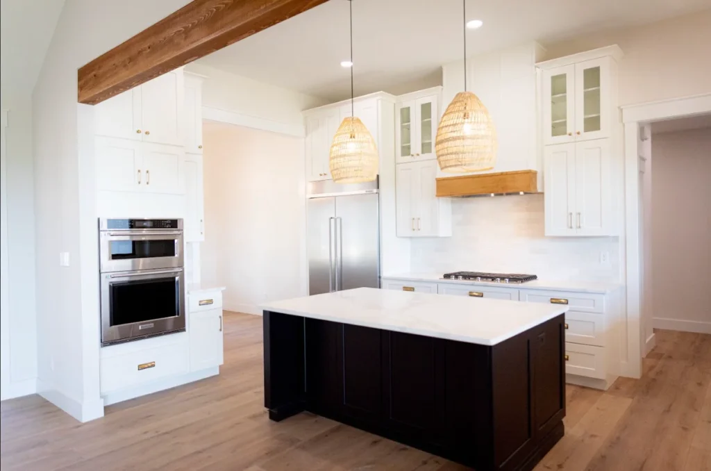 Bright custom kitchen with white quartz countertops, a large waterfall island, white cabinetry, and wood accents in Knoxville, Tennessee.