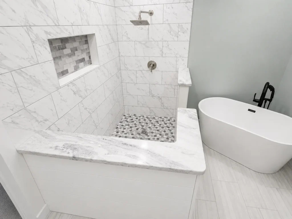 Luxury bathroom featuring White Portinari granite shower cap, threshold, and accents with a walk-in shower and freestanding soaking tub in Knoxville, Tennessee.