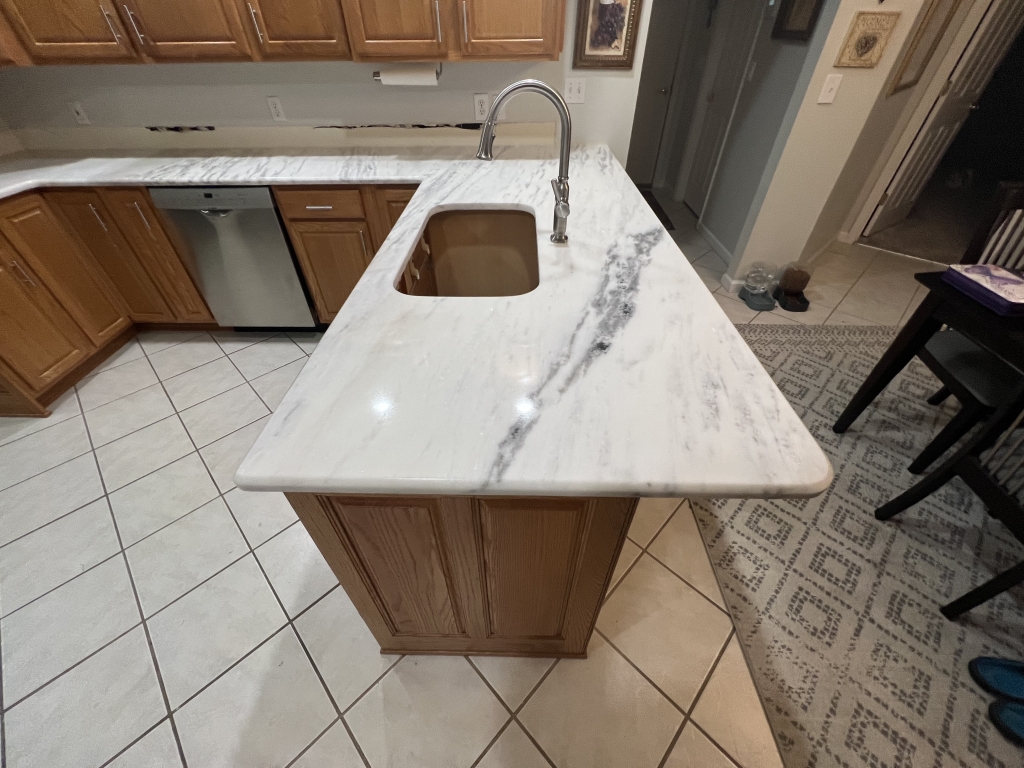 Mont Blanc quartzite countertops with gray veining installed with natural wood kitchen cabinets.