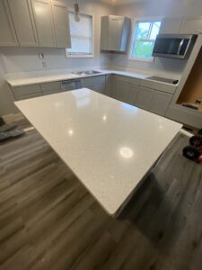 White Lace quartz countertops and large kitchen island paired with gray shaker cabinets.